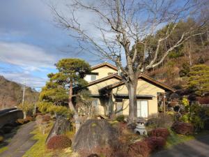 a house with a tree in front of it at BANRYU 萬龍 バンリュウ in Iida
