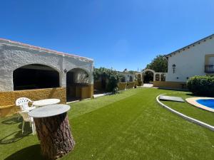 a yard with a tree stump and a table and chairs at Villa Nogueroles in Sanchidrián
