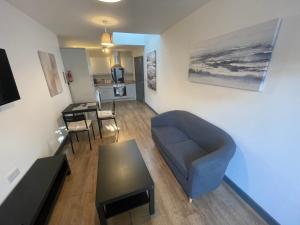 a living room with a couch and a table at Cosy 1 bedroom apartment in the centre of Bolsover in Chesterfield