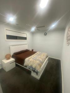 een slaapkamer met een bed en een plafond met verlichting bij Private room in shared house in Wollert