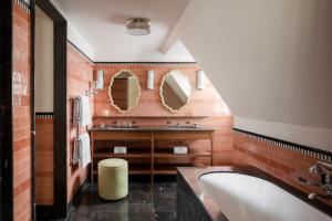 een badkamer met een wastafel en 2 spiegels bij Le Grand Mazarin in Parijs
