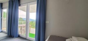 Schlafzimmer mit einer Tür, die auf einen Balkon führt in der Unterkunft Cer de munte in Nucşoara