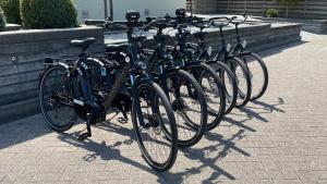 een rij fietsen geparkeerd naast een muur bij Hotel Middelburg in Middelburg