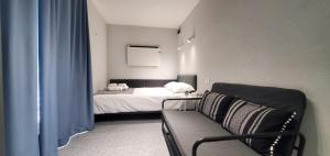 ein Schlafzimmer mit einem Bett und einem Sofa in einem Zimmer in der Unterkunft Cer de munte in Nucşoara