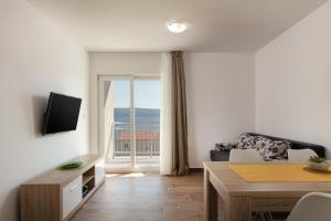 a living room with a couch and a table with a television at Villa LANA*** in Omiš