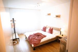 Un dormitorio con una cama con almohadas rosas. en Nest - Hertizentrum 2, en Zug