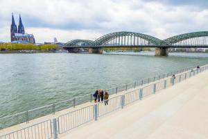 a bridge over a river with people walking on a sidewalk at Apartment Cologne Center in Cologne