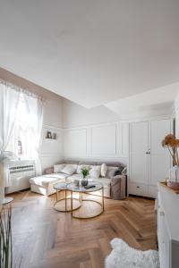 een witte woonkamer met een bank en een tafel bij Hlavna Loft Apartment Kosice in Košice