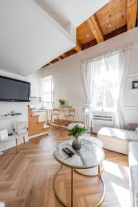 een woonkamer met een bank en een tafel bij Hlavna Loft Apartment Kosice in Košice