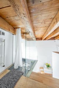een kamer met houten plafonds en een glazen wand bij Hlavna Loft Apartment Kosice in Košice