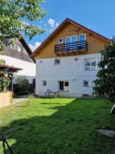 a white house with a wooden roof at Sabina's Cozy House in Buşteni