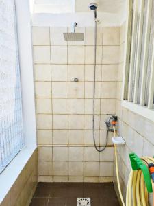 a shower in a bathroom with a tile wall at Chalet Tiziana ~ Una veranda sul mare ~ in Messina