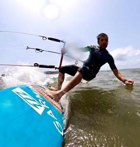 Ein Mann auf einem Surfbrett im Wasser in der Unterkunft Il Salvatore in Masainas