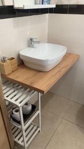 un lavandino bianco su un bancone in legno in bagno di House del Levante a Bari