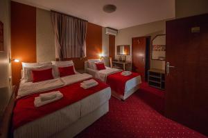 una camera d'albergo con due letti e un bagno di Bell Inn a Leskovac