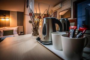 a kitchen counter with a coffee maker and cups on it at Hotel Bell in Leskovac