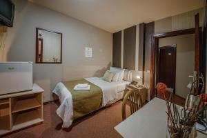 ein Hotelzimmer mit einem Bett und einem TV in der Unterkunft Hotel Bell in Leskovac