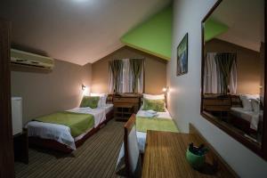 a hotel room with two beds and a mirror at Hotel Bell in Leskovac
