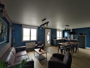a living room with a couch and a table at Le Gîte de Daisy in Saint-Côme-du-Mont