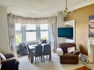 a living room with a table and chairs at Bayside - Breathtaking views of the Clyde in Rothesay