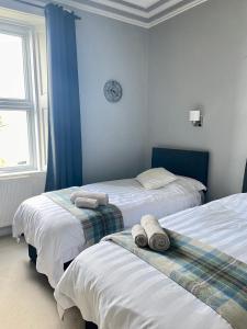 1 dormitorio con 2 camas y toallas. en Bayside - Breathtaking views of the Clyde en Rothesay