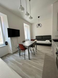 a living room with a table and chairs and a couch at Luxury apartment + garage in Trieste