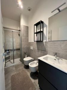a bathroom with a sink and a toilet and a shower at Luxury apartment + garage in Trieste