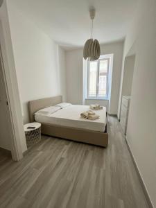 a white bedroom with a bed and a window at Luxury apartment + garage in Trieste