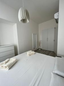 a large white bedroom with two towels on a bed at Luxury apartment + garage in Trieste