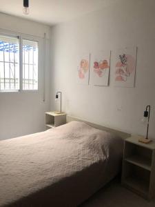 a white bedroom with a bed and a window at Piso los franchutes in Cabra