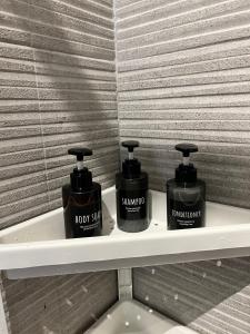 two bottles of soap on a shelf in a bathroom at Luxury apartment + garage in Trieste