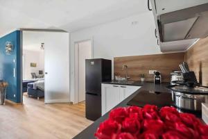 a kitchen with red roses on a counter top at TomsFlat VW Bulli Apartment Wolfsburg in Wolfsburg