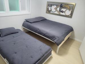 a bedroom with two beds and a picture on the wall at Brand New 2 Bedroom Apartment in Seoul