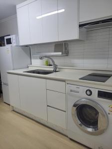 a kitchen with a washing machine and a sink at Brand New 2 Bedroom Apartment in Seoul