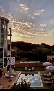 a pool with a table and chairs next to a building at Kopernikus Apartments in Ulcinj