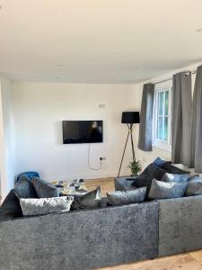 a living room with a large gray couch with pillows at Dune Delight in Camber