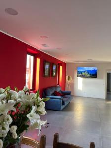 sala de estar con paredes rojas, sofá y flores en GC Petit Palais, en Gallarate