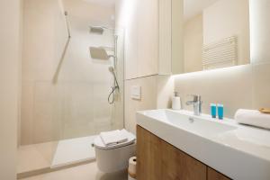 a white bathroom with a sink and a shower at Centrum Nauki Kopernika Luxury Studio in Warsaw