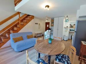 a living room with a table and a blue couch at Rêves de montagne, T2 bis, Luchon, wifi, parking gratuit, 4 personnes in Luchon