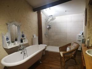 a bathroom with a bath tub and a sink at Les Granges de la Leigne, Ruffec in Condac