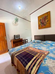 a bedroom with a bed and a tv on a table at Rinjani Homestay in Pangandaran