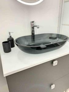 a bathroom sink with a black glass bowl at Le Jules - Ambiance anglaise in Margny-lès-Compiègne