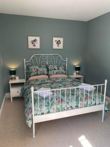 a bedroom with a white bed and two night stands at Brooklands Guest House in Llandrindod Wells