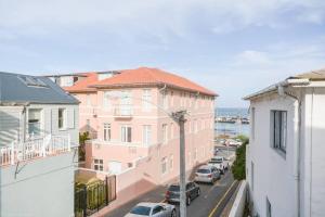 a view of a city street with buildings and cars at Sunny Windsor Apartment in Kalk Bay in Cape Town