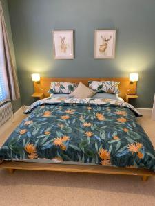 una camera da letto con un grande letto e un piumone colorato di Brooklands Guest House a Llandrindod Wells