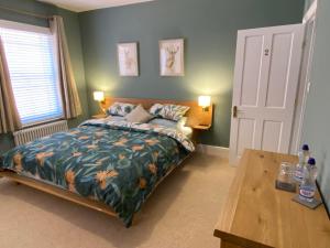a bedroom with a bed and a wooden table at Brooklands Guest House in Llandrindod Wells