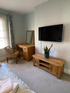 a bedroom with a flat screen tv on a wall at Brooklands Guest House in Llandrindod Wells