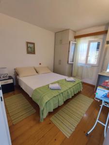 a bedroom with a large bed with two towels on it at Apartment Nanica Prigradica in Blato