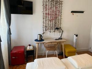 パーソ・デ・アルコスにあるBeautiful Private Room next to Lisbon - NEWのデスク、テーブル(赤いスーツケース付)が備わる客室です。