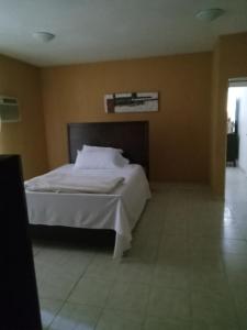 ein Schlafzimmer mit einem weißen Bett in einem Zimmer in der Unterkunft Heidy House in Arecibo